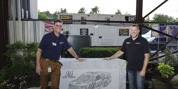Tony Stewart and David McGrath hang out by the granite retirement gift NHMS gave Stewart.