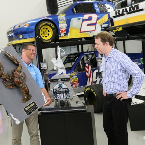 New Hampshire Motor Speedway Executive Vice President and General Manager David McGrath (left) presents the 2020 Loudon the Lobster plaque to NASCAR Cup Series driver Brad Keselowski (right) on Wednesday. Keselowski earned the giant crustacean on Aug. 2, 2020 when he landed in victory lane for the Foxwoods Resort Casino 301.