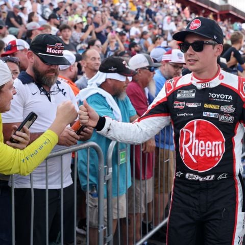 Two-time New Hampshire Motor Speedway NASCAR Cup Series race winner Christopher Bell, driver of the No. 20 Joe Gibbs Racing Toyota, fist-bumps race fans during driver introductions at North Wilkesboro Speedway on July 19.