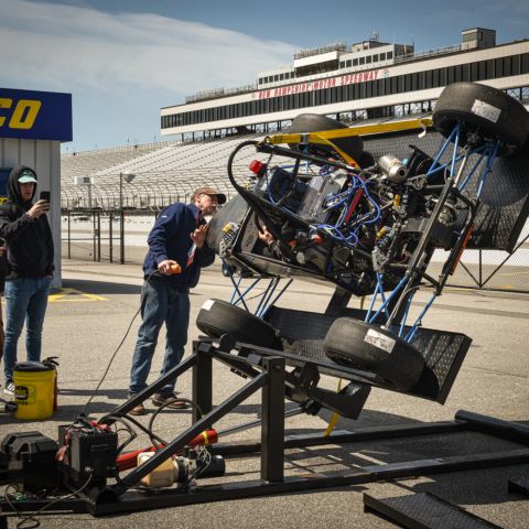 A student-designed and -built race car experiences the tilt test during the 2022 Formula Hybrid + Electric competition at New Hampshire Motor Speedway.
