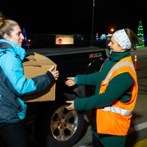A local woman donates a box of food for the Loudon Food Pantry on Nov. 29, 2022 at the 12th annual Gift of Lights presented by Ambetter at New Hampshire Motor Speedway.
