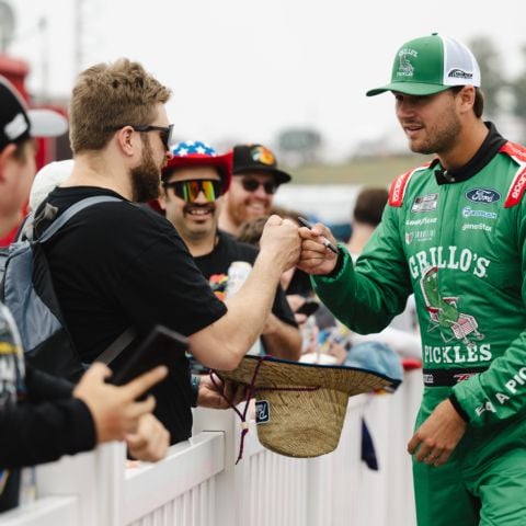 Todd Gilliland, NASCAR Cup Series driver of the No. 34 Front Row Motorsports Ford, fist bumps fans along the red carpet at New Hampshire Motor Speedway on June 23, 2024.