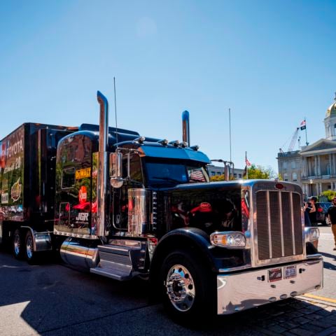 The No. 20 NASCAR Cup Series hauler passes in front of the State Capitol on Main Street in Concord, N.H. Friday during New Hampshire Motor Speedway’s first-ever hauler parade through downtown to kick off New England’s only NASCAR Playoffs weekend.