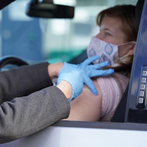 A patient receiving the COVID-19 vaccine from a volunteer at New Hampshire’s second vaccine super site at New Hampshire Motor Speedway on Saturday, March 27.